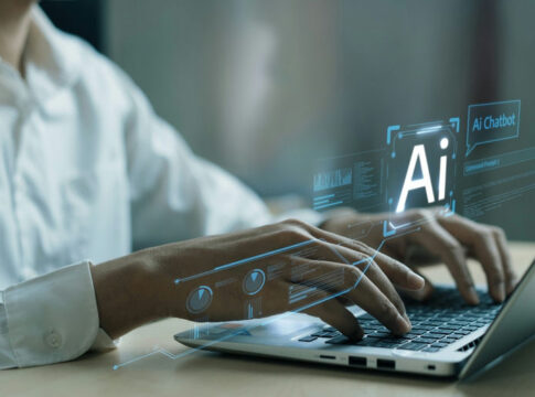 Hands typing on laptop with AI holograms.